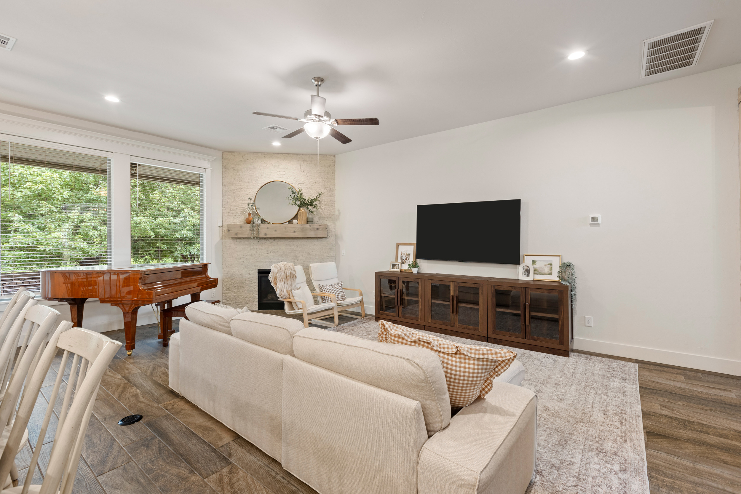Staged living room with a piano and fireplace